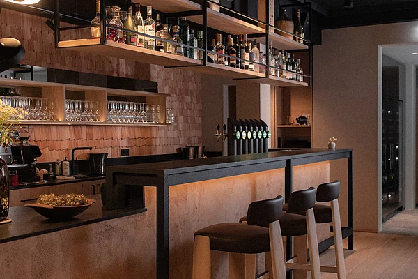 moderne Bar mit gepolsterten Holzhockern im Restaurant Zirngast Schladming